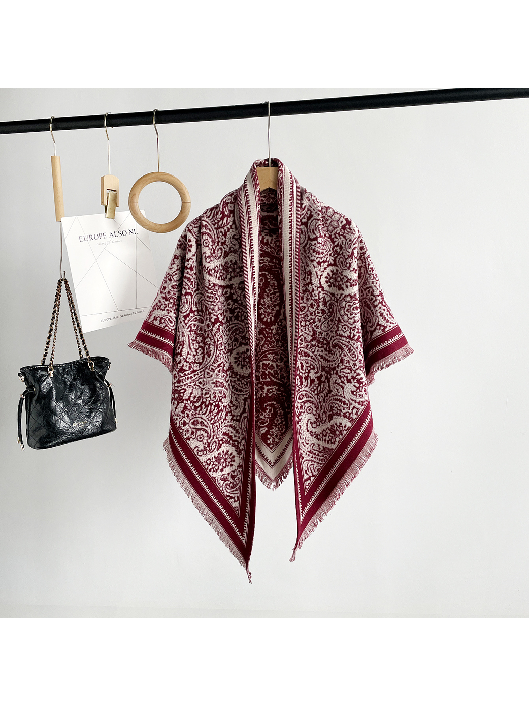 Burgundy paisley triangle scarf with contrasting border and short fringe, full hanging view
