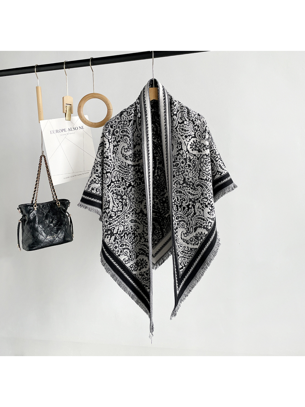 Black paisley triangle scarf with contrasting border and short fringe, full hanging view