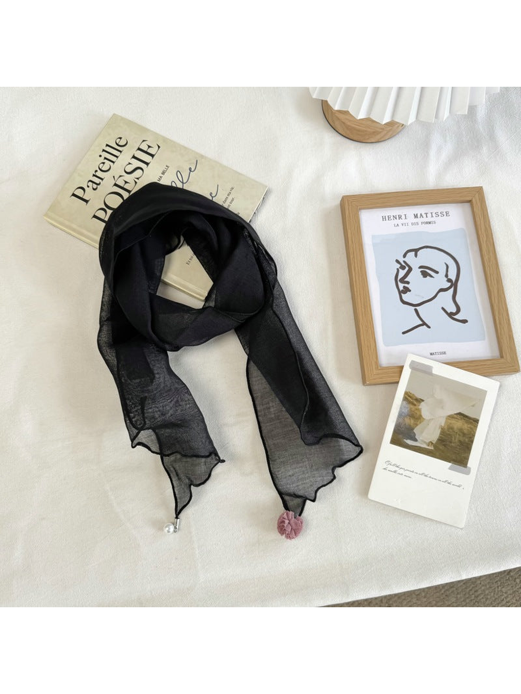 Black sheer scarf with wavy edges and pom-pom and bead end accents