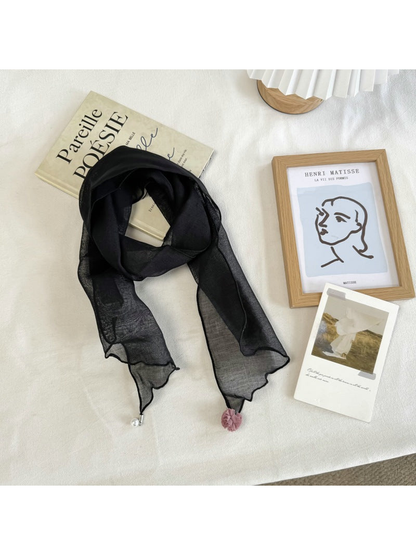 Black sheer scarf with wavy edges and pom-pom and bead end accents