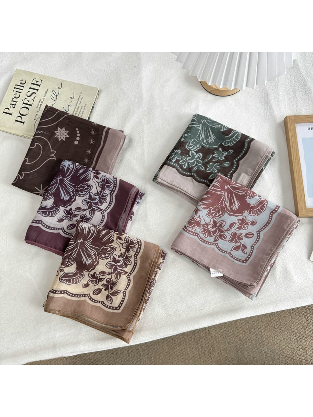 Five patterned square scarves folded together