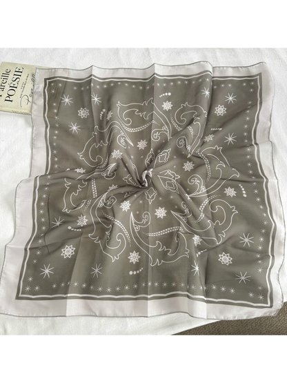 Greige square scarf with star and scroll motifs displayed open