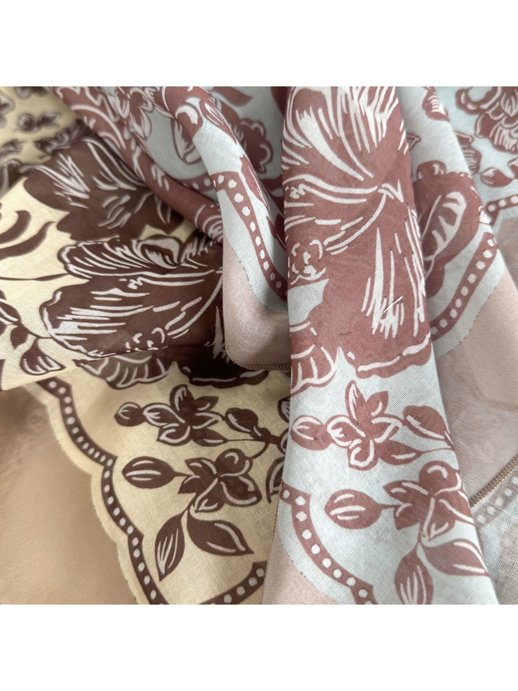 Close-up of contrasting floral patterns and draped scarf folds