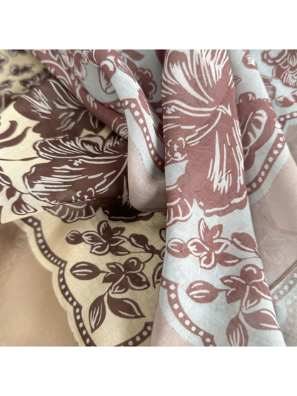 Close-up of contrasting floral patterns and draped scarf folds