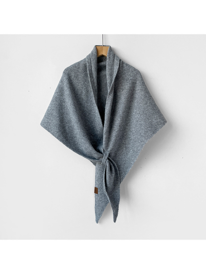 Light gray triangle shawl with a heathered knit texture, tied on a wooden hanger