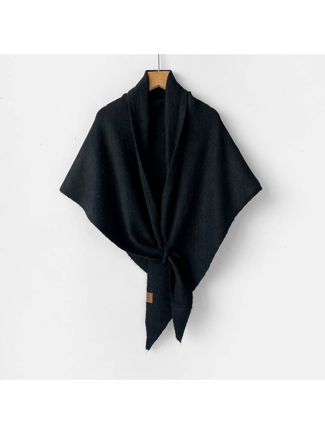 Black triangle shawl tied on a wooden hanger