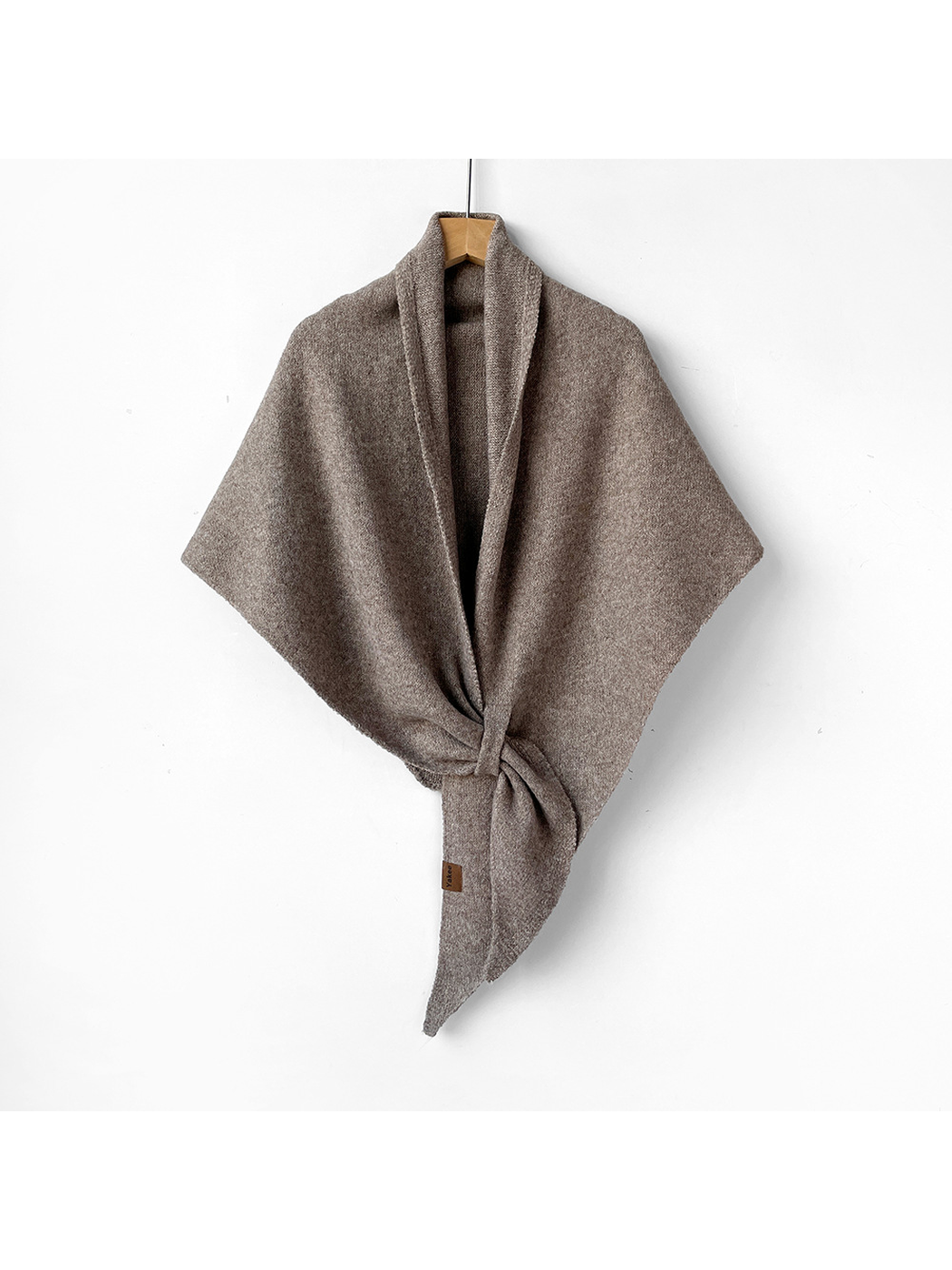 Greige triangle shawl tied on a wooden hanger