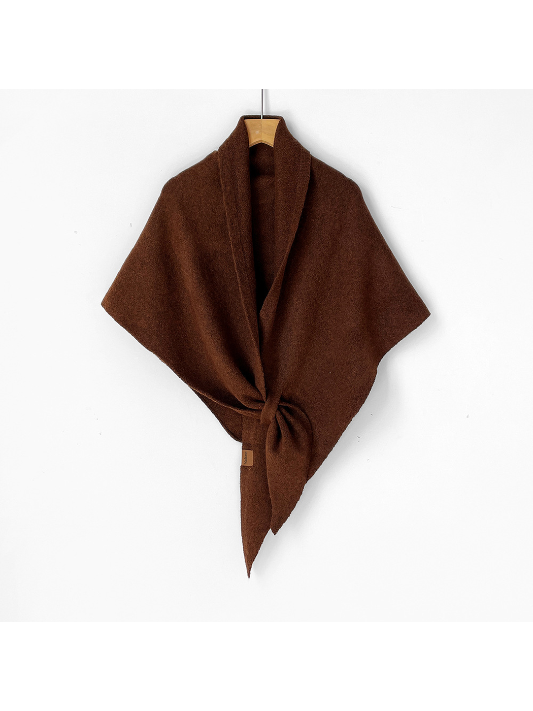 Brown triangle shawl tied on a wooden hanger