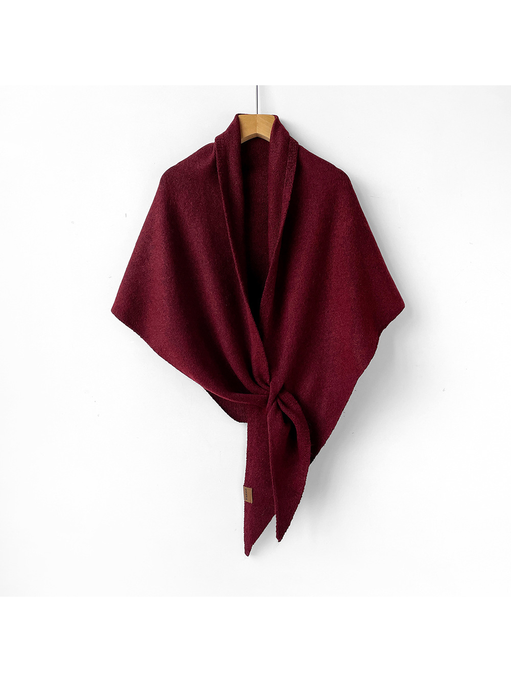 Burgundy triangle shawl tied on a wooden hanger