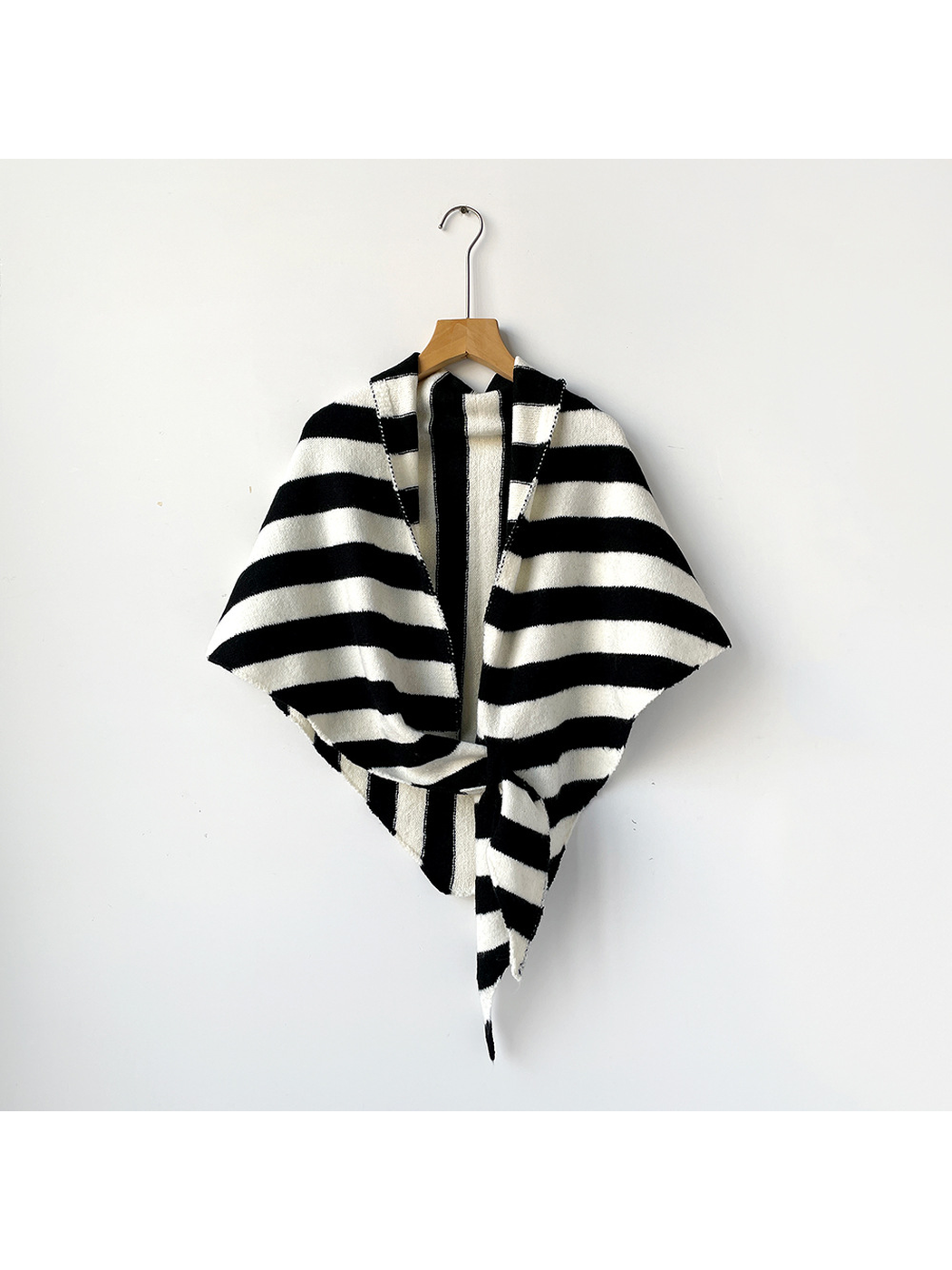 Black and ivory striped triangle shawl tied on a wooden hanger