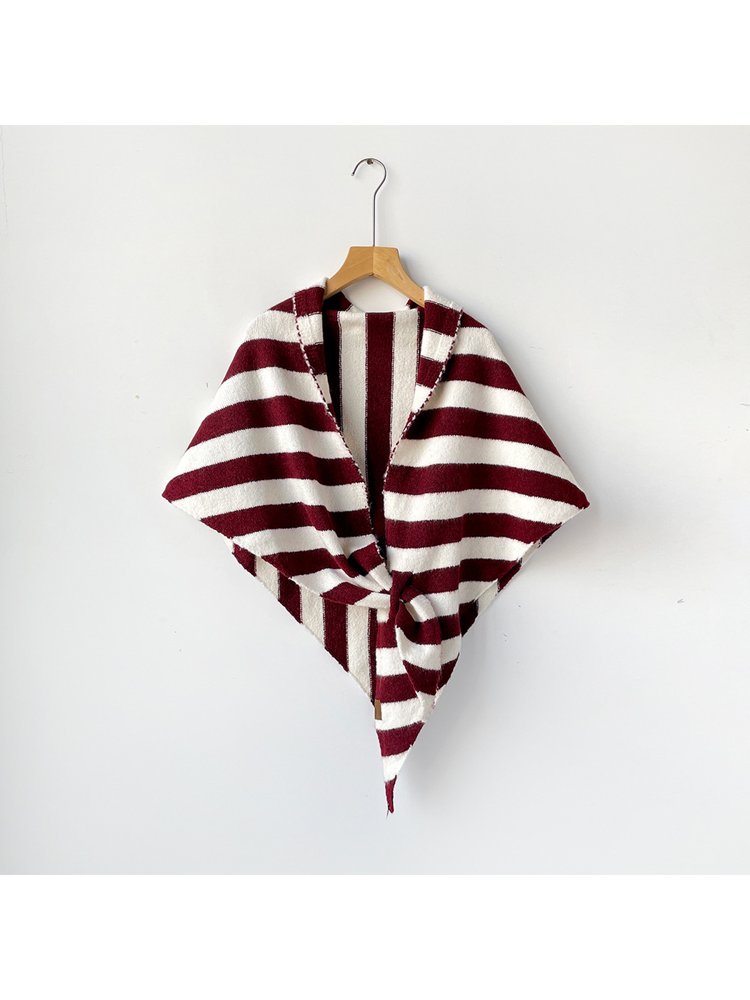Burgundy and ivory striped triangle shawl tied on a wooden hanger