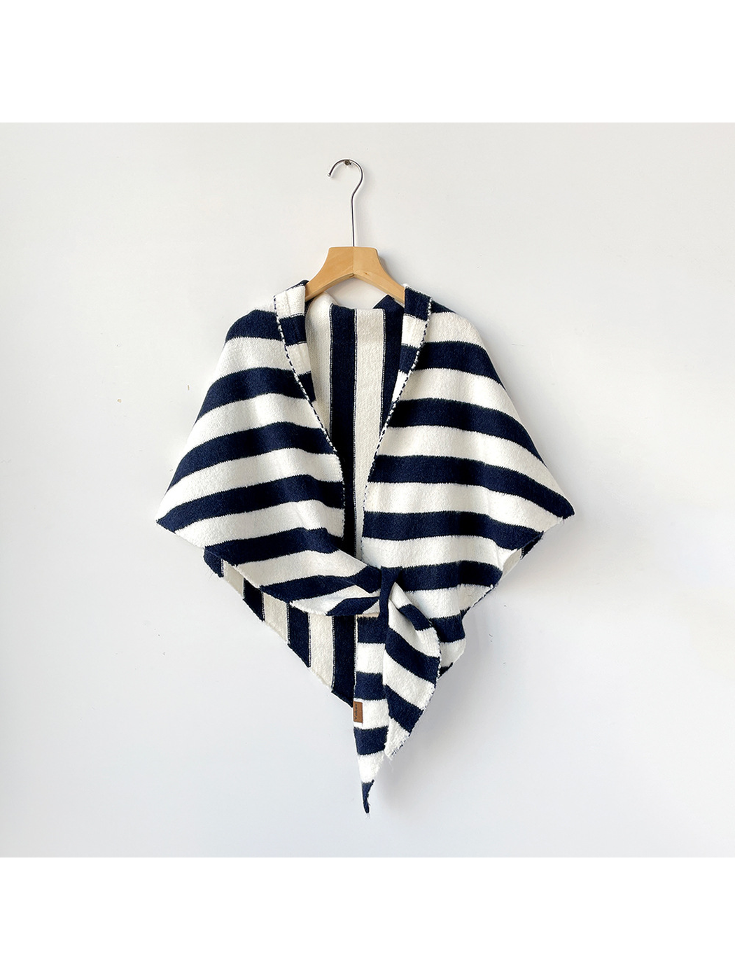 Navy and ivory striped triangle shawl tied on a wooden hanger