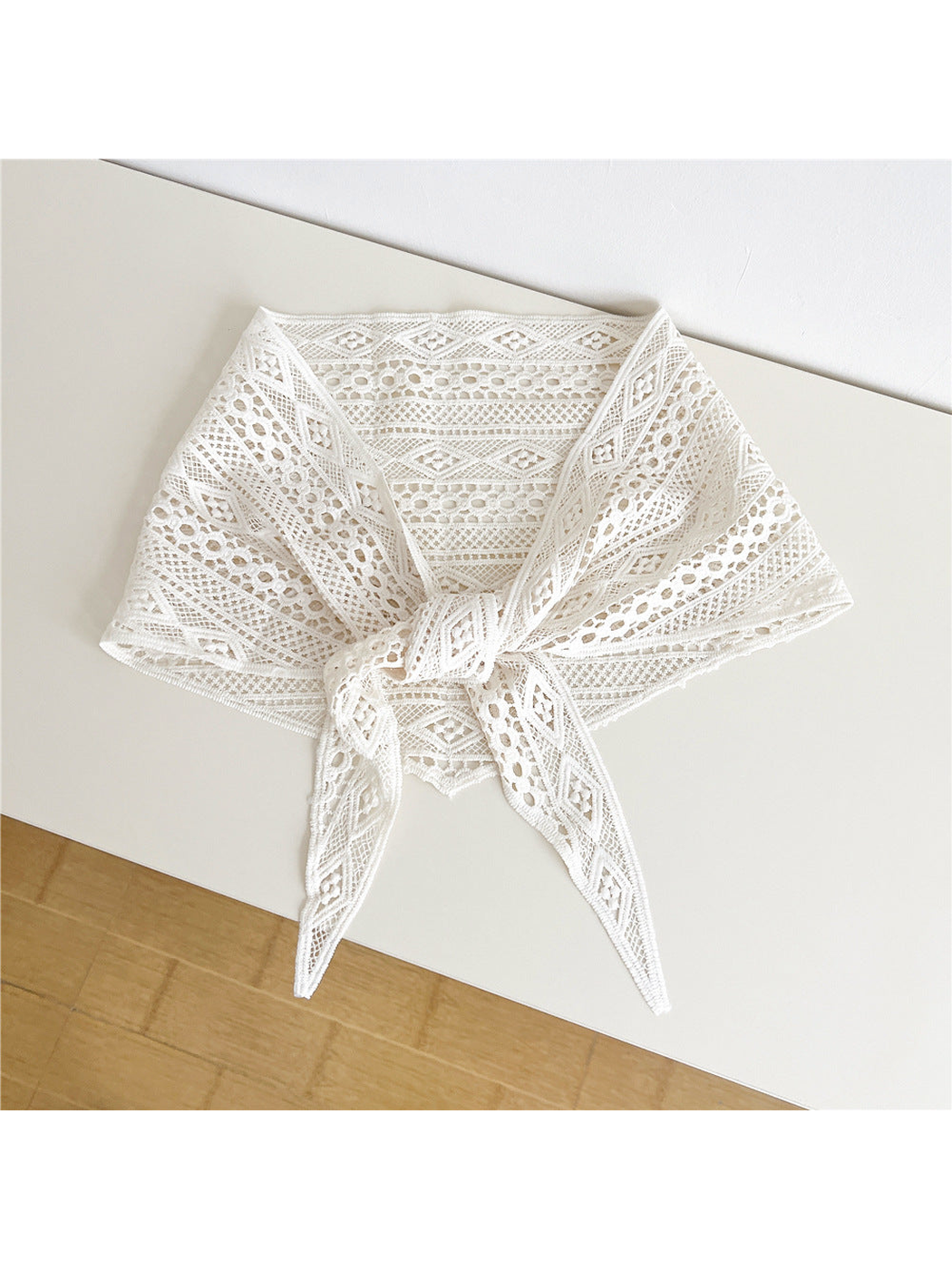 Ivory openwork triangle scarf tied at the front