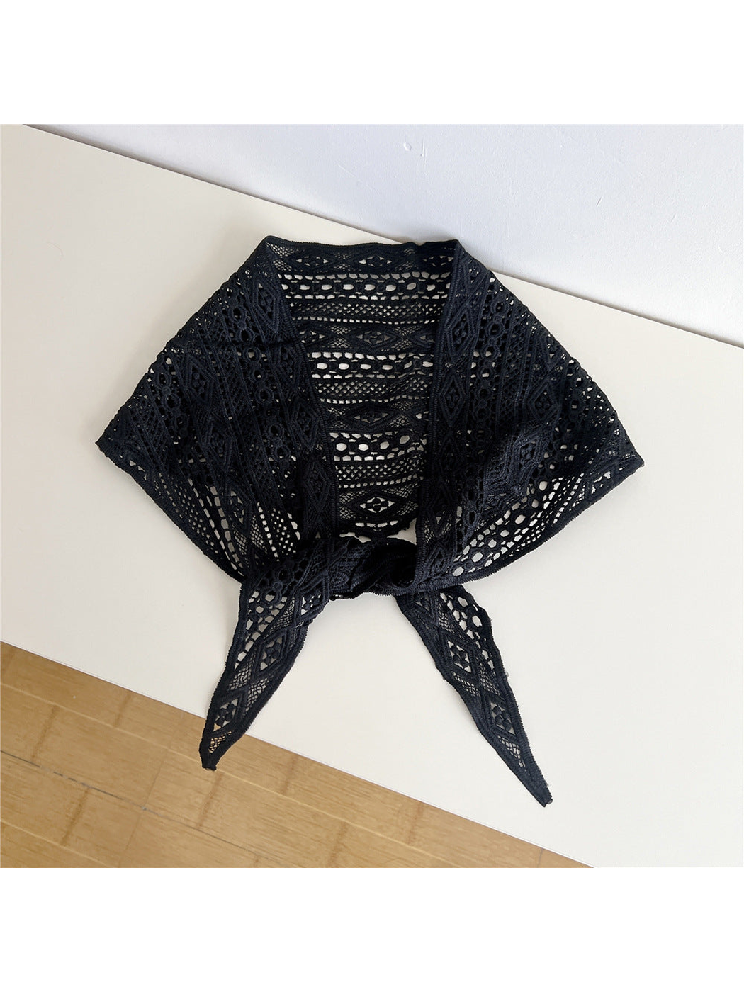Black openwork triangle scarf tied at the front