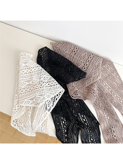 Ivory, Black and Light Coffee openwork triangle scarves arranged in overlapping folds