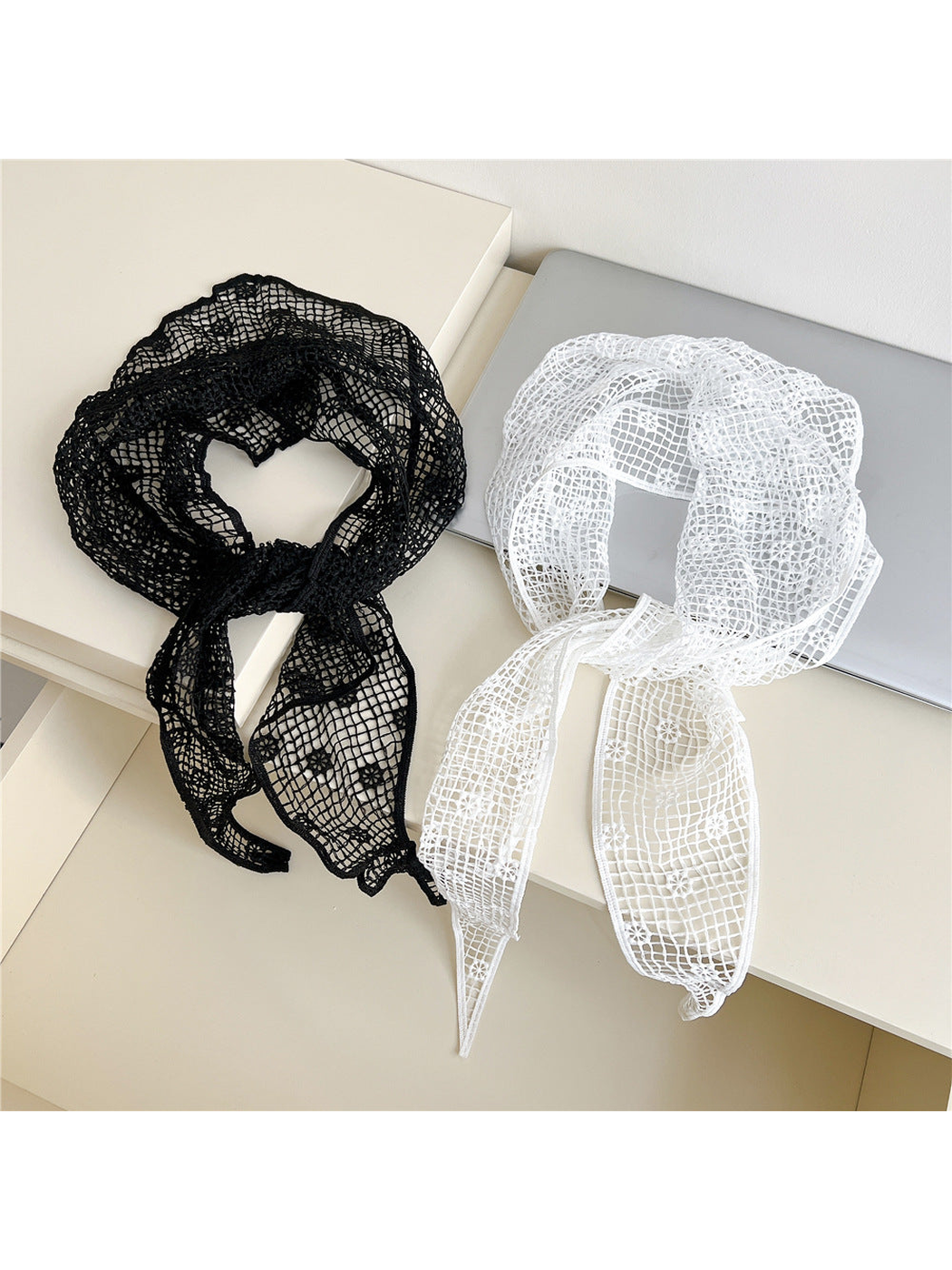 Black and white openwork triangle scarves arranged side by side