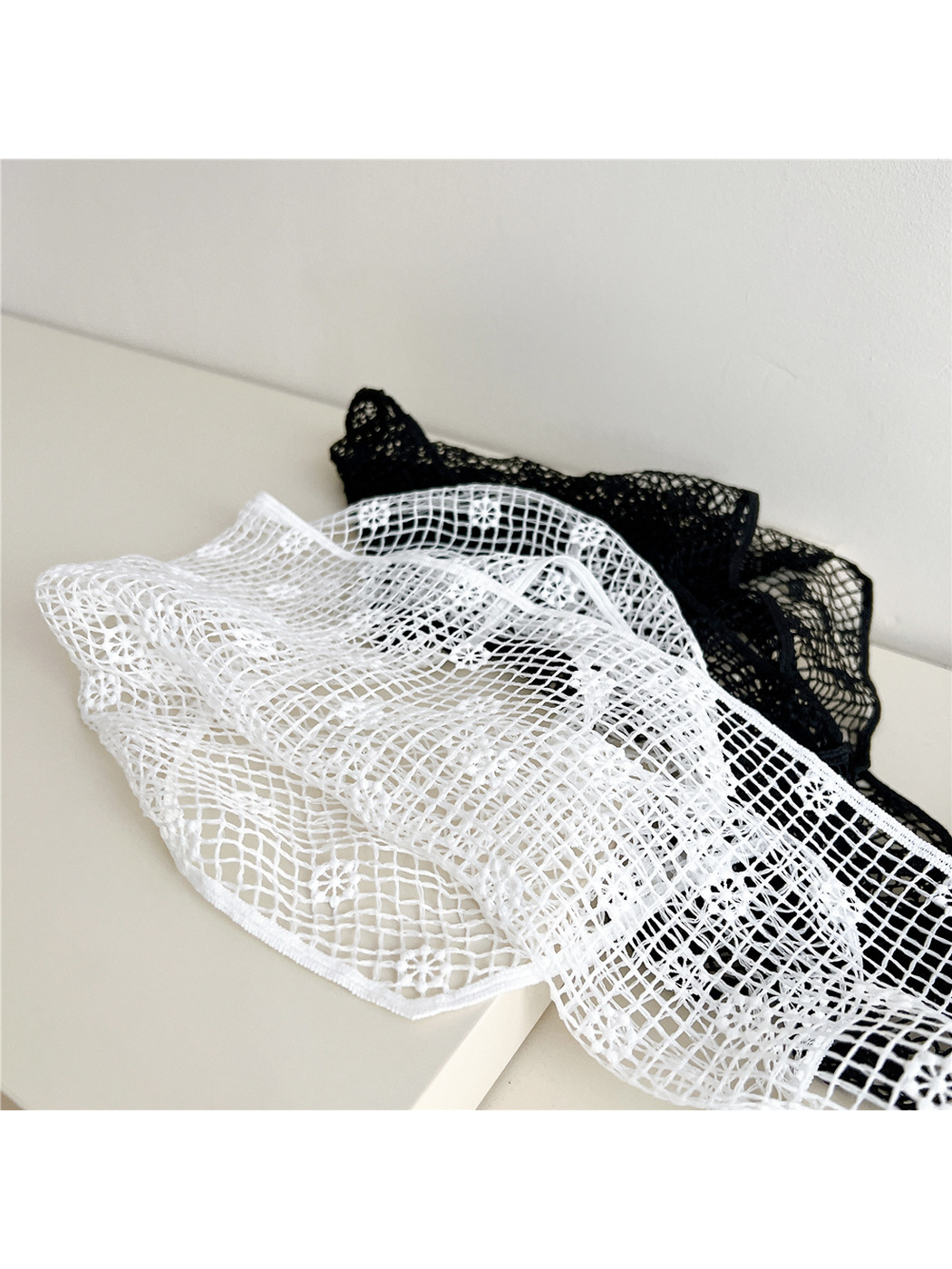 Close-up of white openwork grid and small floral motifs