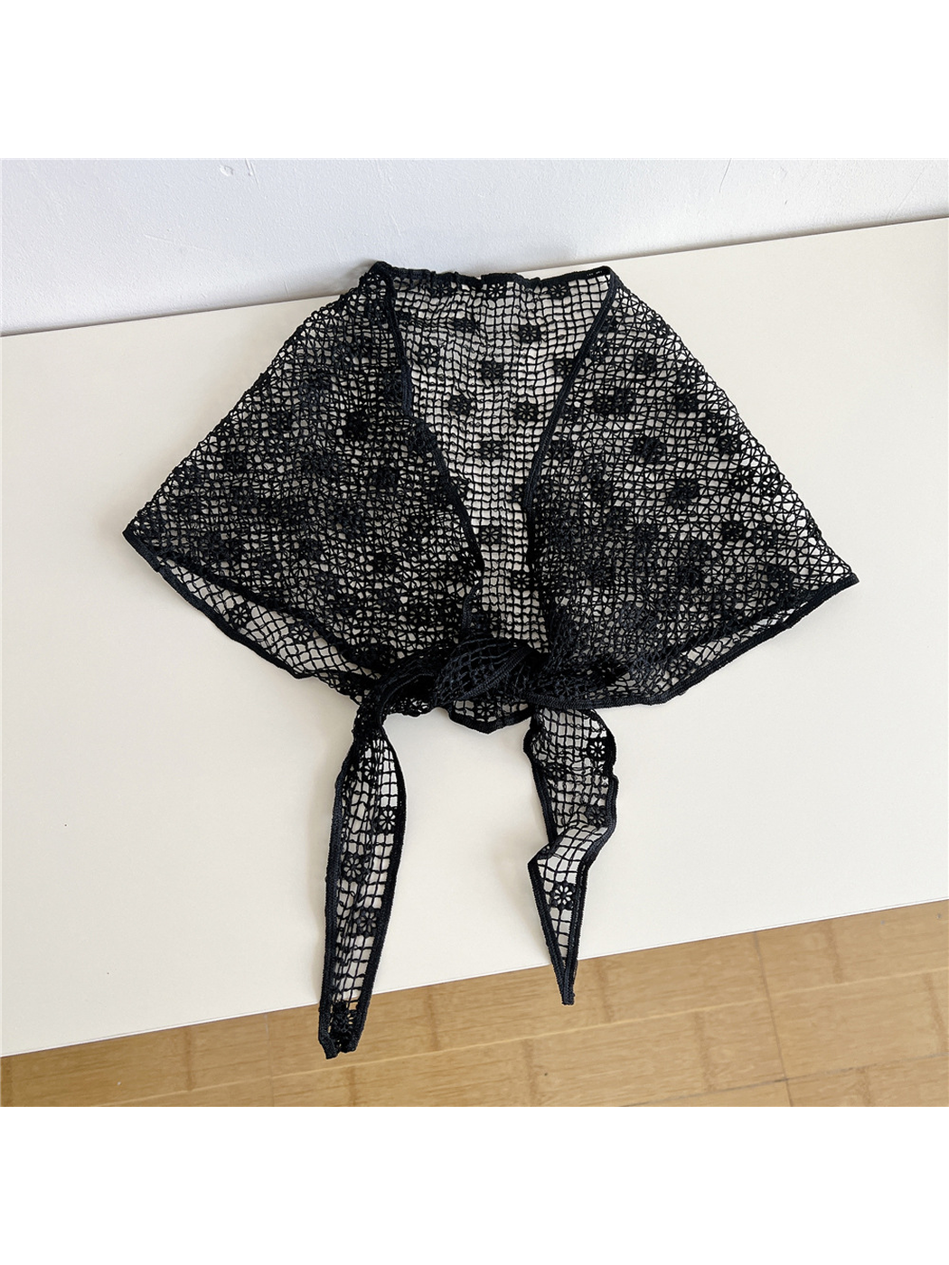 Black openwork triangle scarf tied at the front