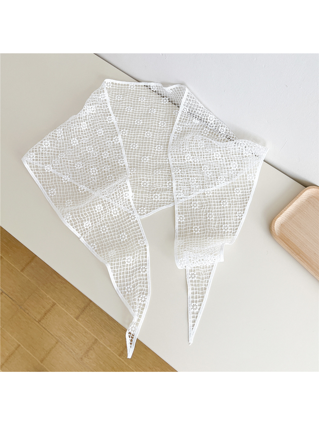 White openwork triangle scarf laid flat with long pointed ends