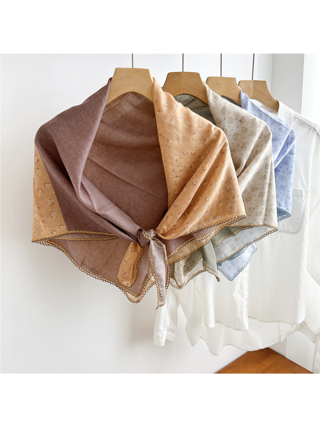 Multiple two-tone floral scarves tied and displayed together on hangers