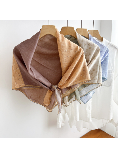 Multiple two-tone floral scarves tied and displayed together on hangers