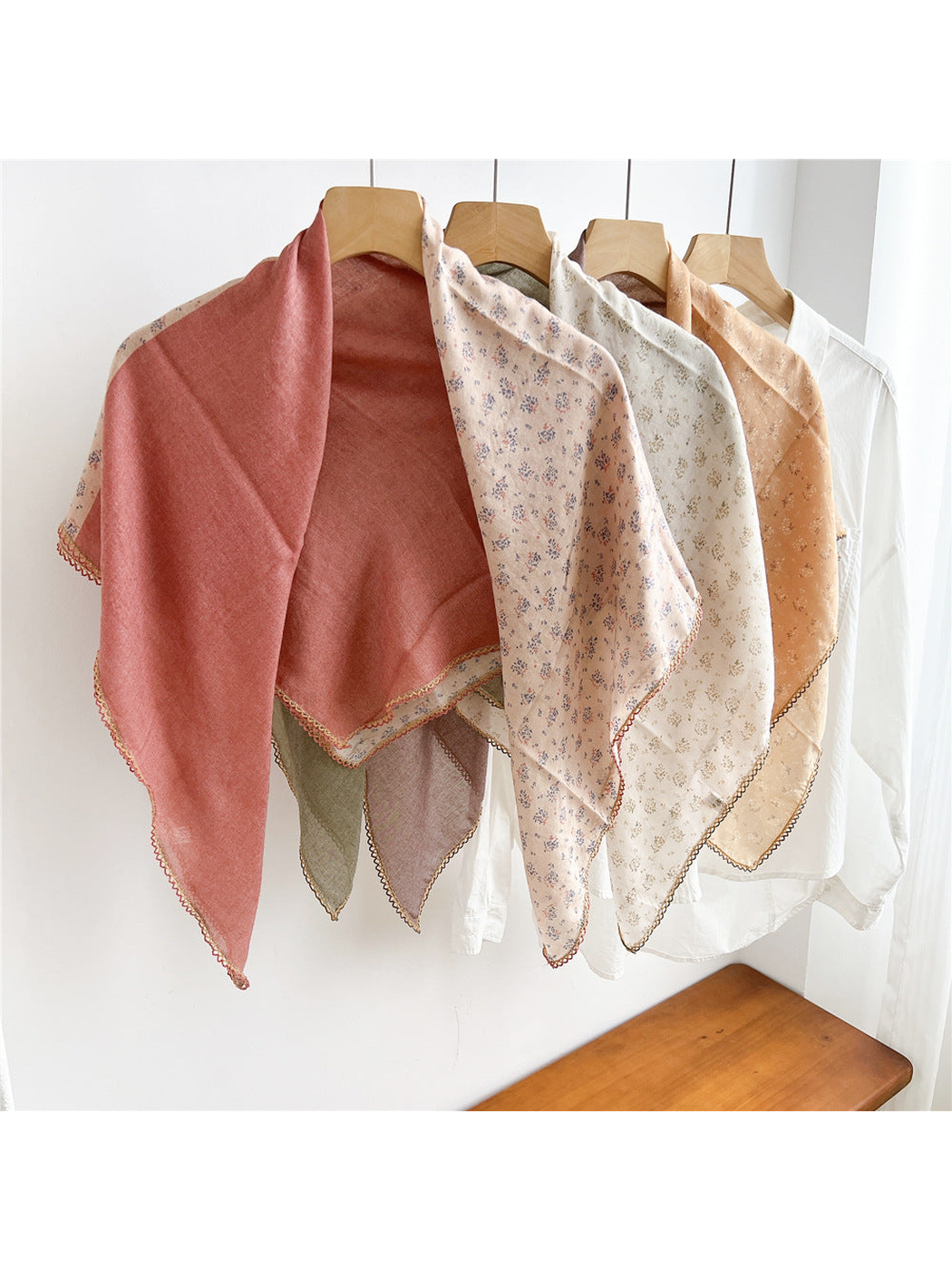 Multiple two-tone floral scarves draped open together on hangers