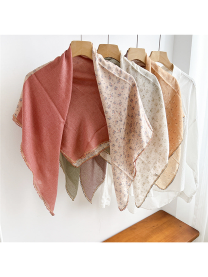 Multiple two-tone floral scarves draped open together on hangers