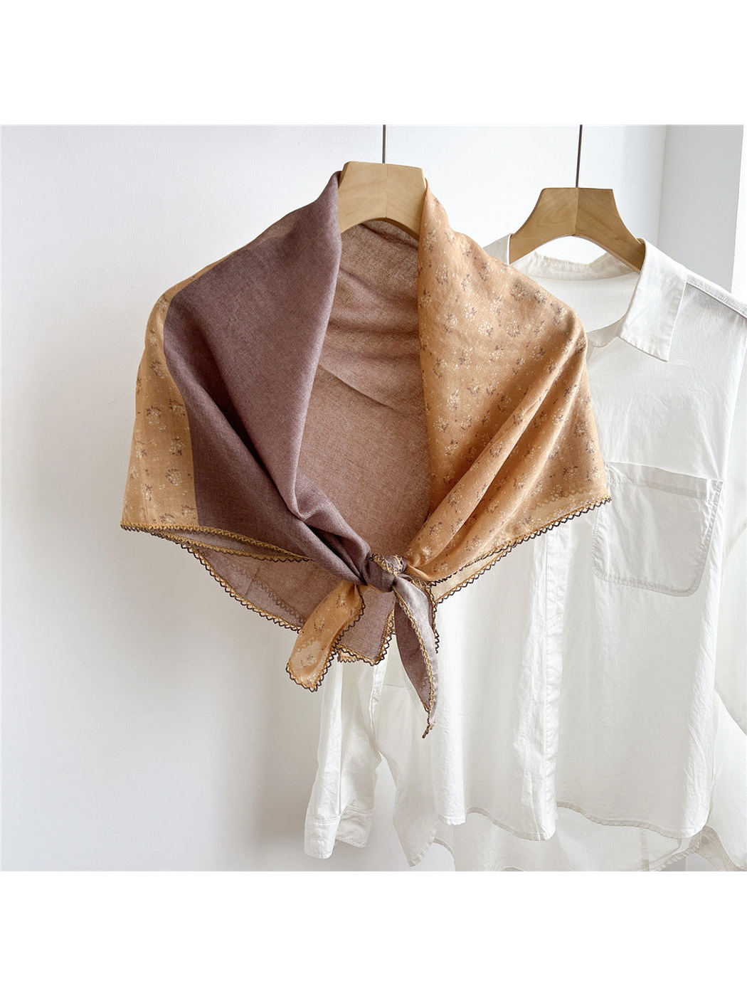 Camel two-tone floral scarf tied on a hanger