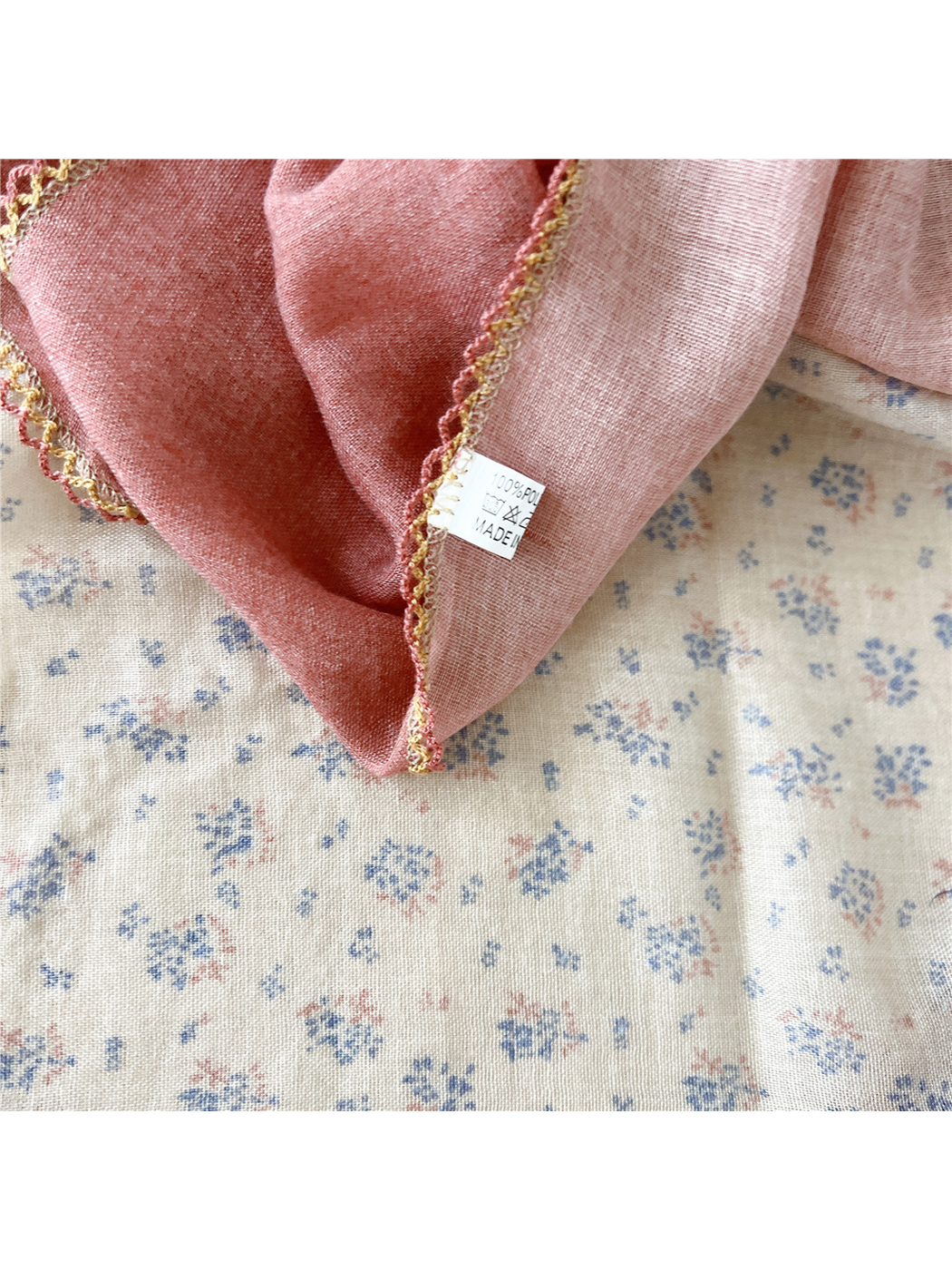 Close-up of the small floral print, woven-look texture and looped edge trim