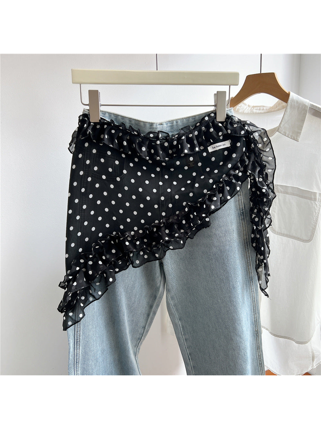 Black sheer polka dot triangle scarf styled over light blue jeans