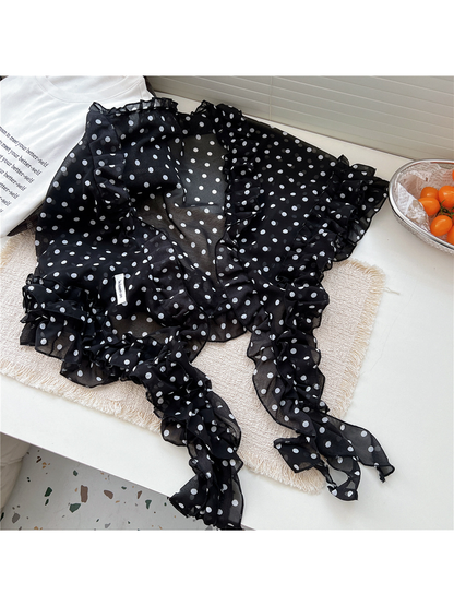 Black polka dot scarf arranged in a gathered tabletop display