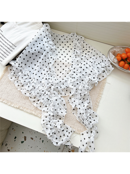 White polka dot scarf arranged in a flat tabletop display