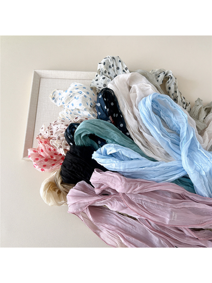 Close arrangement of solid and polka-dot crinkled scarf variations