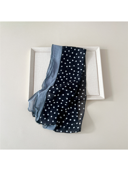 Folded black dot scarf showing the contrasting blue-gray panel and sheer patterned section
