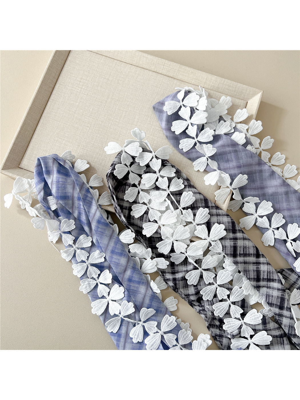 Close-up of plaid scarf colors and raised white leaf lace trim