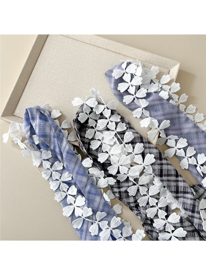 Close-up of plaid scarf colors and raised white leaf lace trim