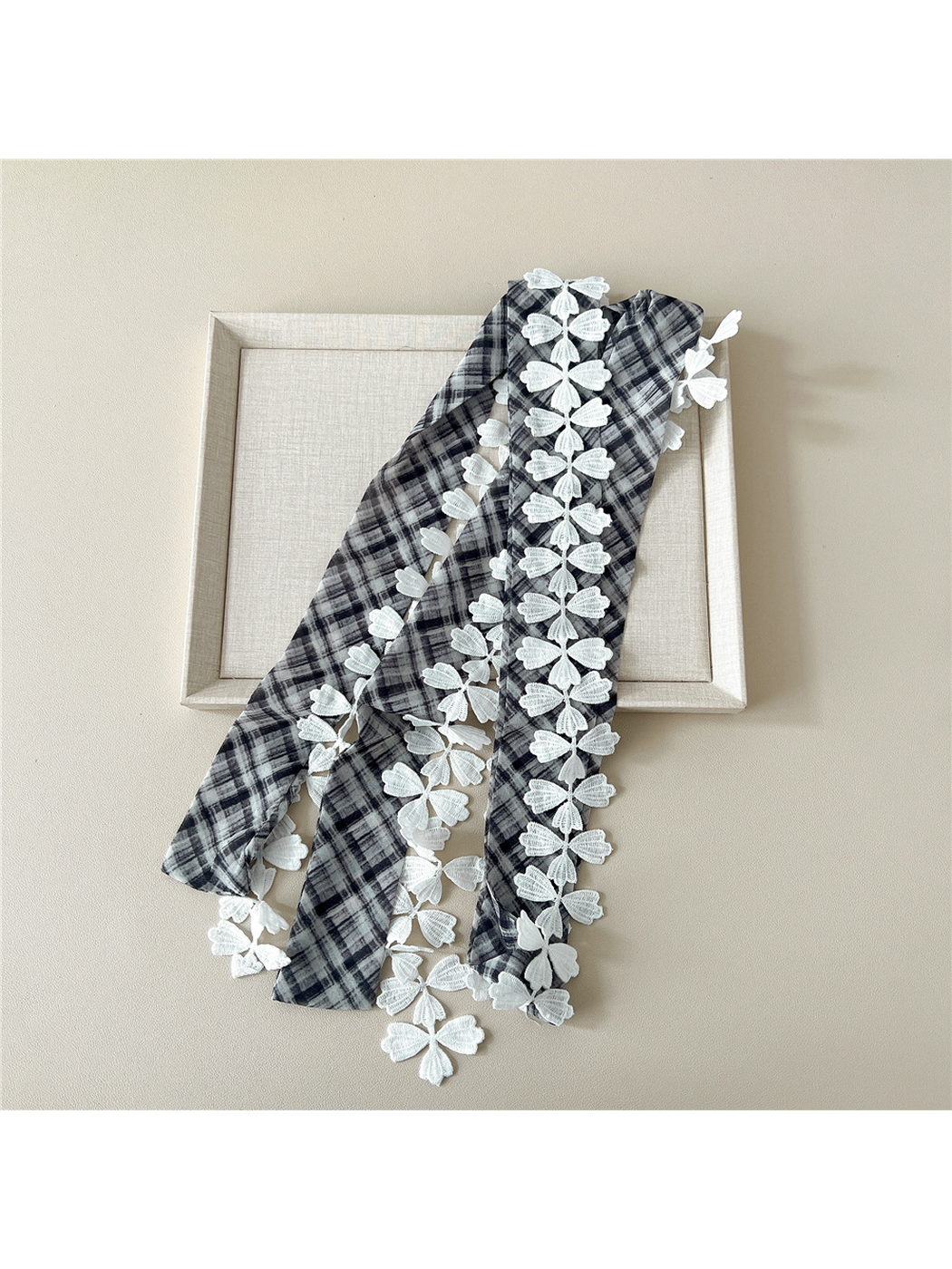 Black Gray plaid narrow scarf laid lengthwise to show the white leaf lace trim