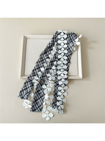 Black Gray plaid narrow scarf laid lengthwise to show the white leaf lace trim