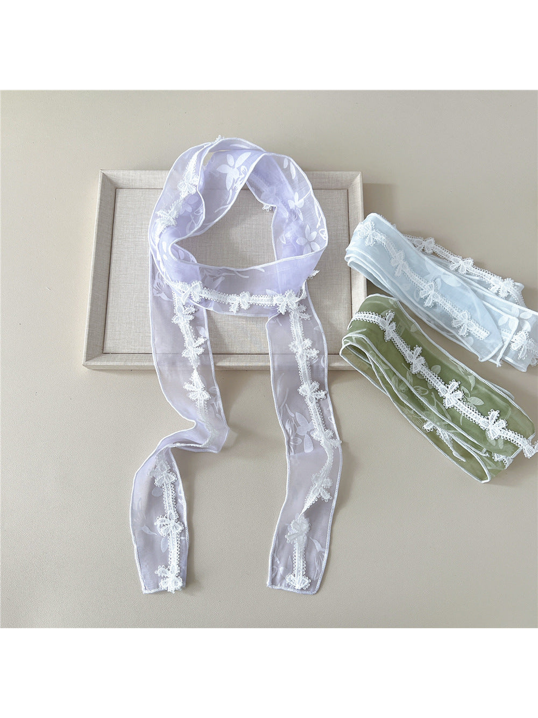 Light Purple scarf displayed with folded Light Blue and Green scarves