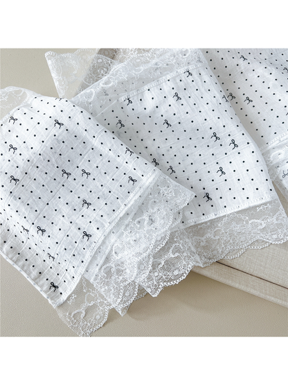 Close-up of dotted bow pattern and scalloped floral lace trim