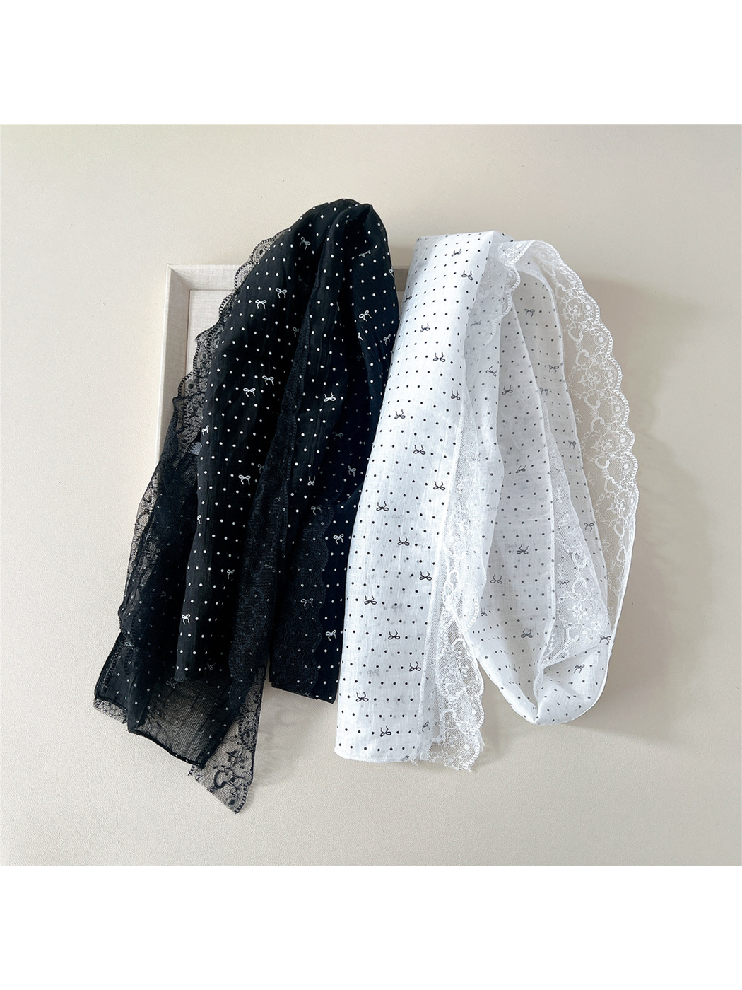 White and Black long scarves displayed in hanging folds