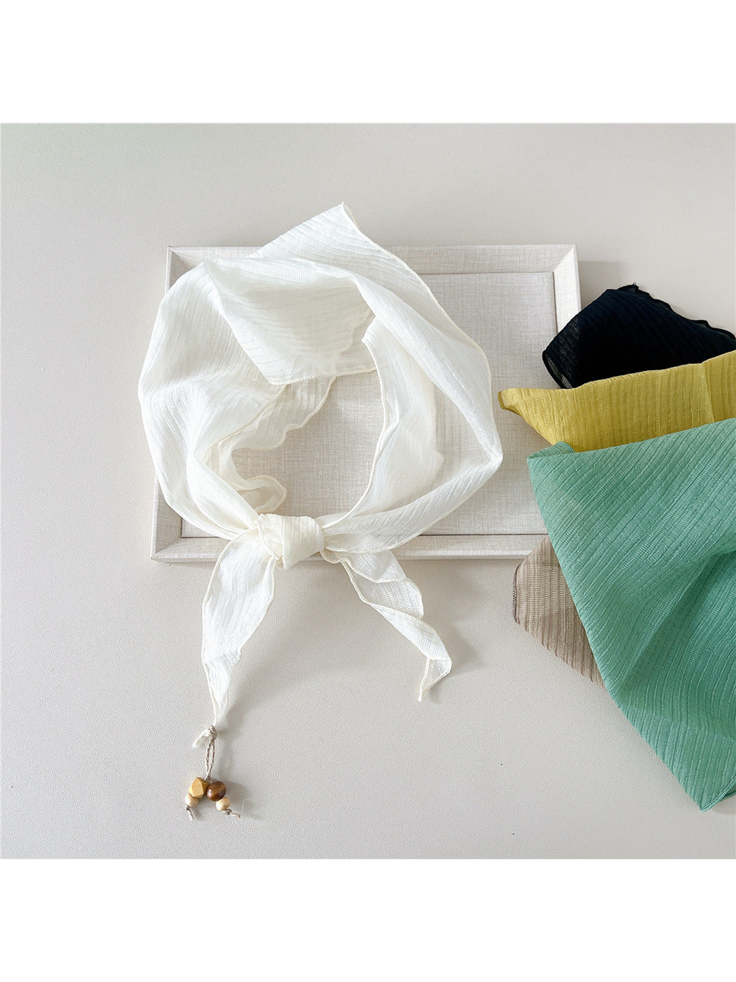 Ivory textured scarf tied beside navy, yellow, mint and beige options