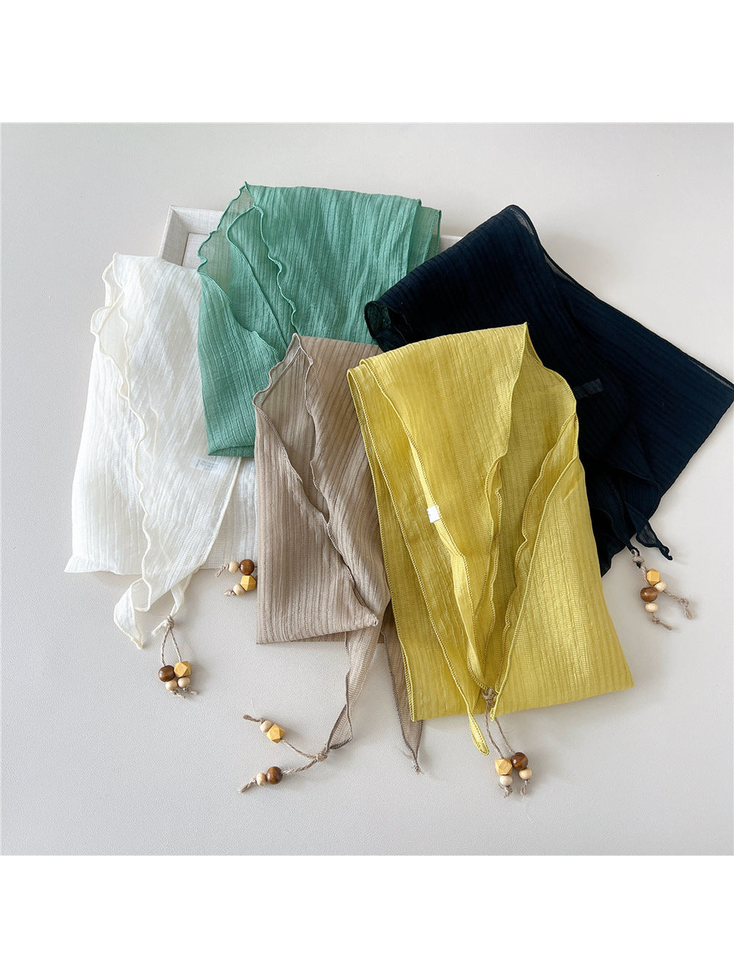 Ivory, mint, navy, yellow and beige triangle scarves displayed together