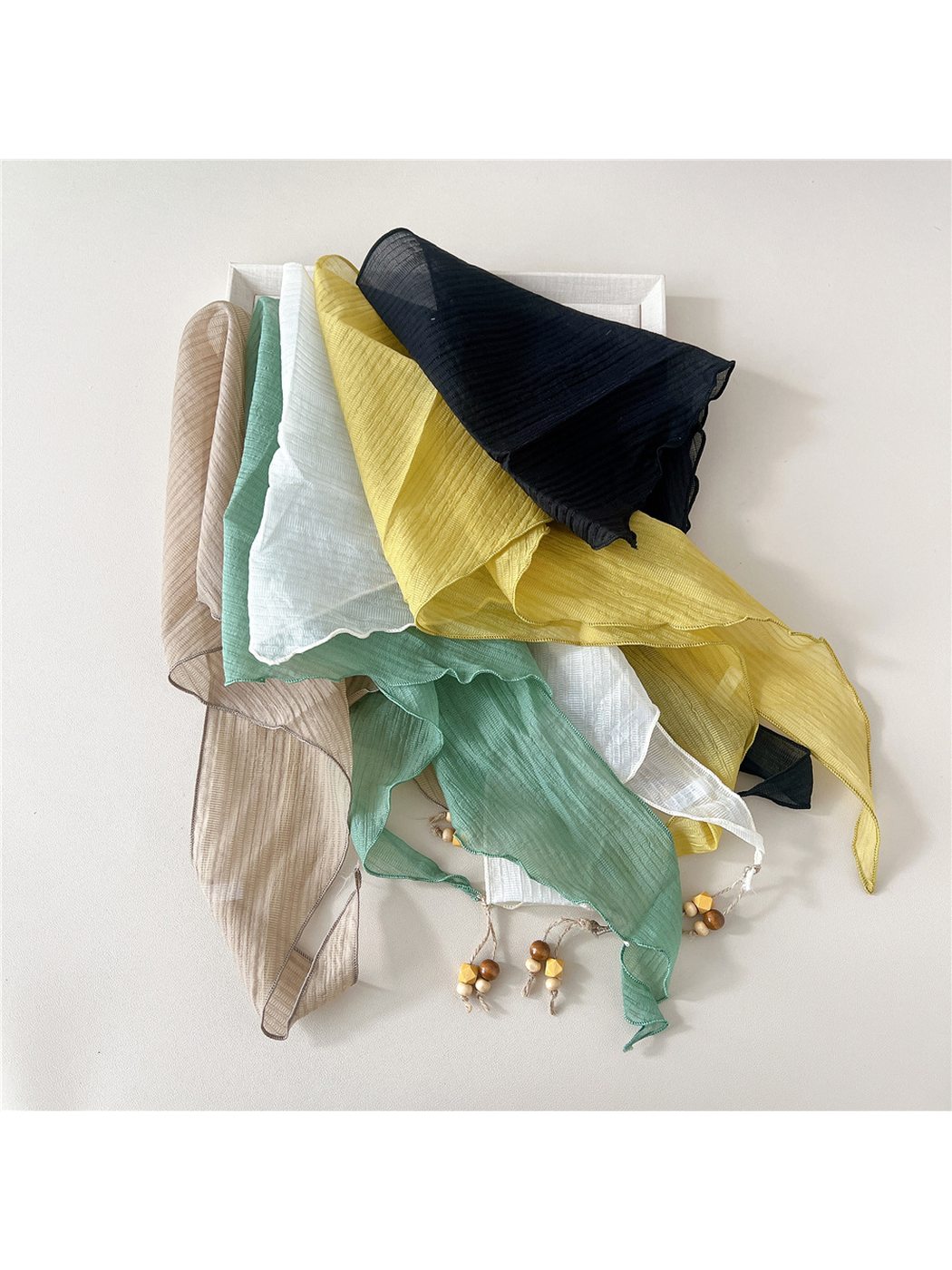 Ivory, beige, mint, yellow and navy textured scarves draped together