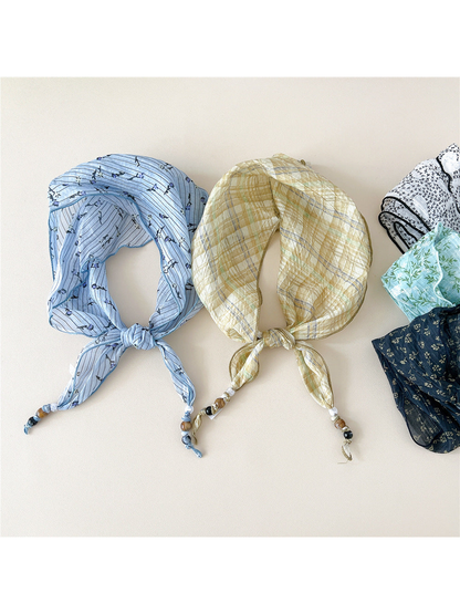 Blue striped and yellow plaid triangular scarves displayed with assorted patterns