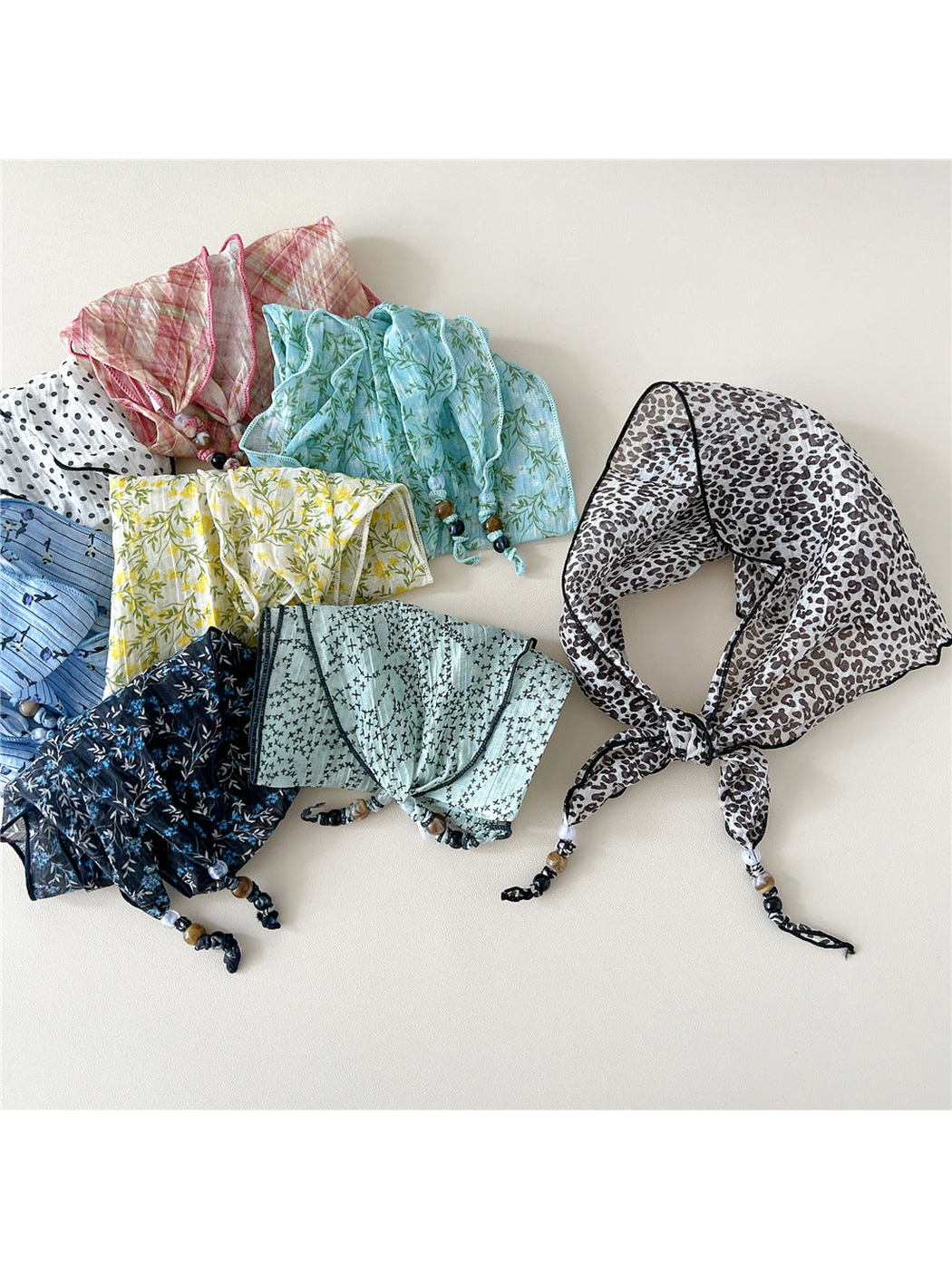 Assorted patterned triangular scarves displayed together