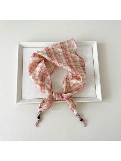 Pink Plaid triangular scarf tied with beaded tips