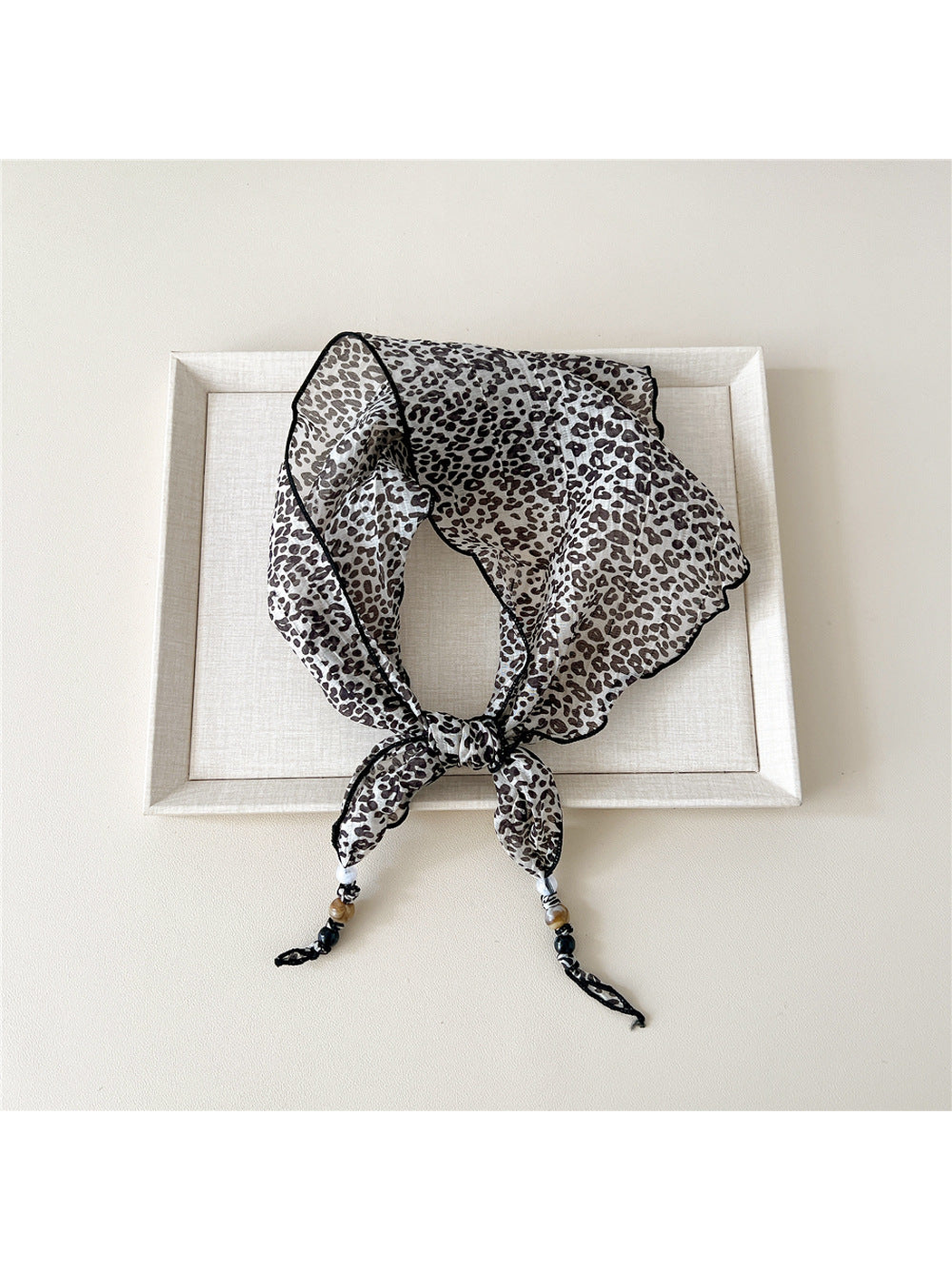 Ivory Leopard triangular scarf tied with beaded tips