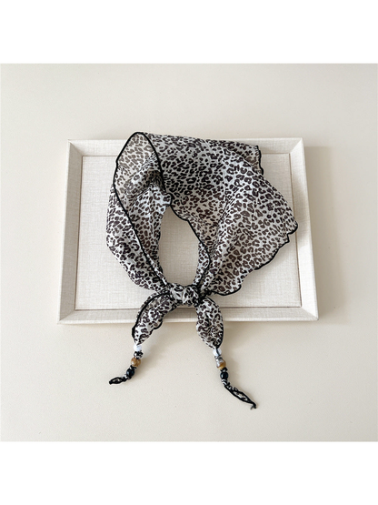 Ivory Leopard triangular scarf tied with beaded tips