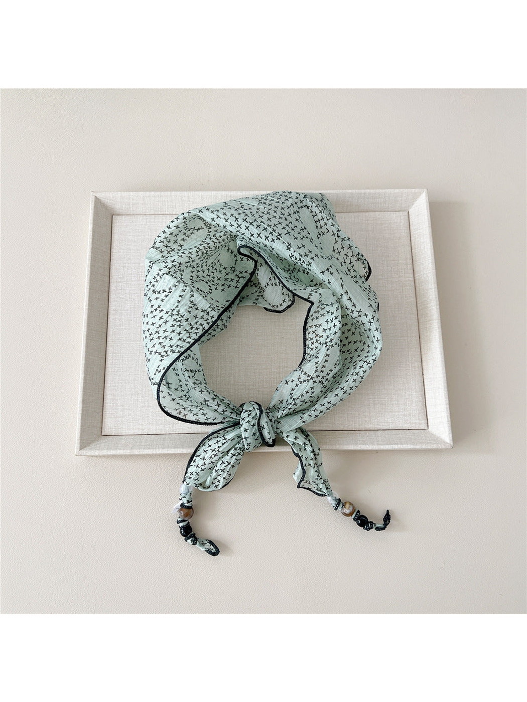 Mint Cross triangular scarf tied with beaded tips